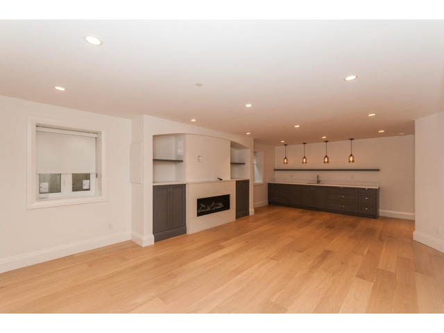 Open-concept living area with hardwood floors and modern lighting fixtures. - 6448 Argyle Ave, West Vancouver