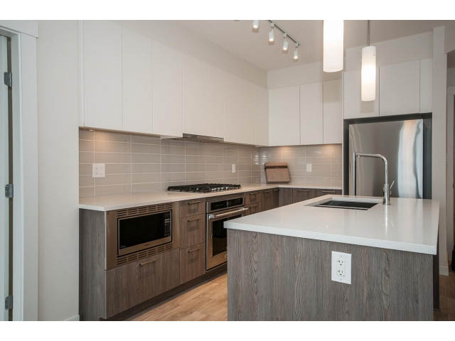 Bright kitchen with modern cabinetry, hardwood floors, and stainless steel appliances. - 303 - 615 East 3rd Street, North Vancouver