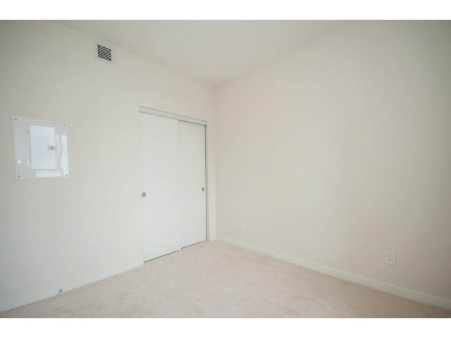 Den with sliding closet doors and carpeted floor. - 303 - 615 East 3rd Street, North Vancouver