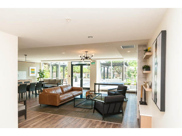 Furnished living room with hardwood floors and a city view. - 303 - 615 East 3rd Street, North Vancouver