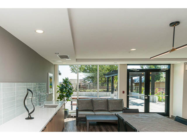 Furnished living room with hardwood floors, city view, and modern decor. - 303 - 615 East 3rd Street, North Vancouver