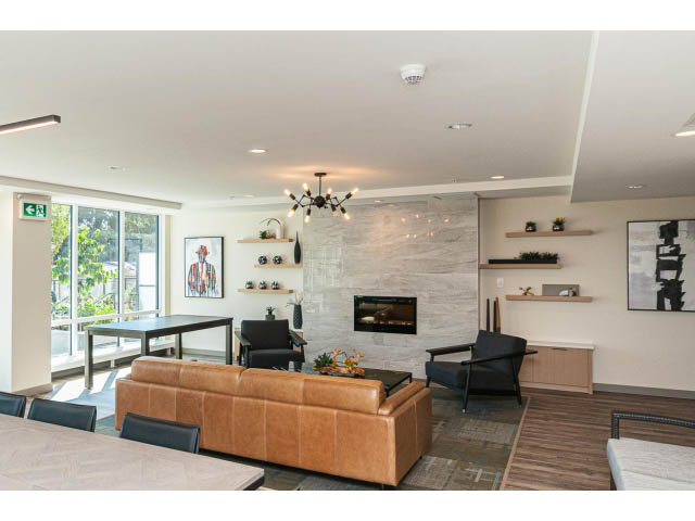 Spacious living room with modern decor, open shelving, and a view of the city. - 303 - 615 East 3rd Street, North Vancouver
