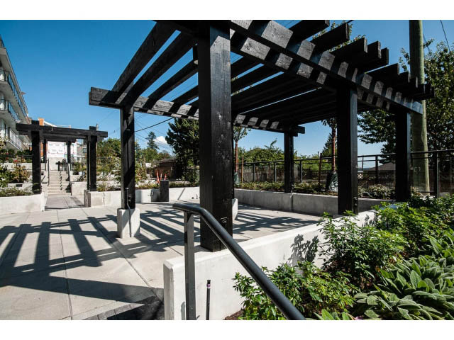 Furnished patio with wooden pergola and greenery. - 303 - 615 East 3rd Street, North Vancouver