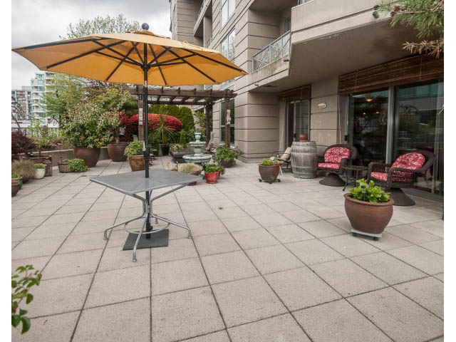 Furnished patio with outdoor furniture, potted plants, and a large umbrella. - 310 - 160 E 13th St, North Vancouver
