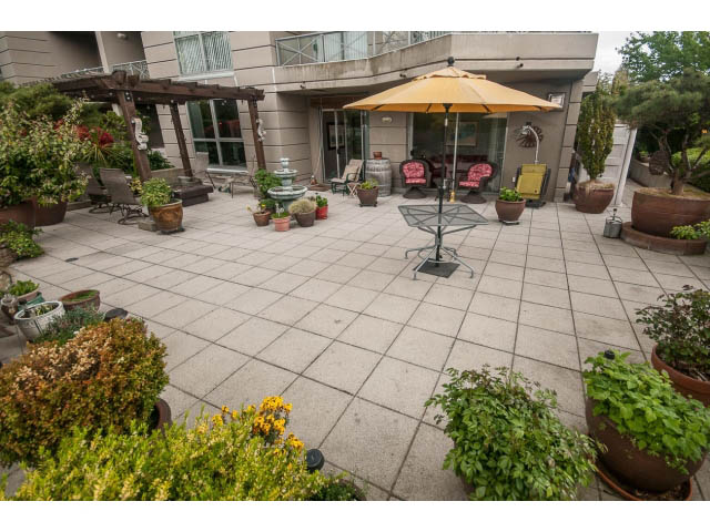 Furnished patio with potted plants, outdoor furniture, and a fountain. - 310 - 160 E 13th St, North Vancouver