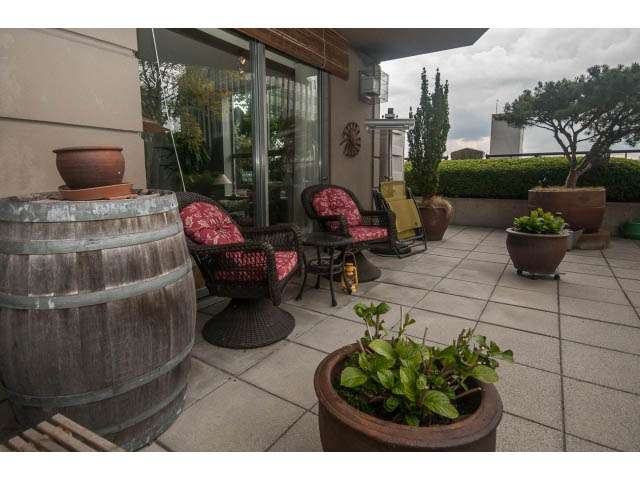 Furnished patio with outdoor seating, plants, and a barrel. - 310 - 160 E 13th St, North Vancouver