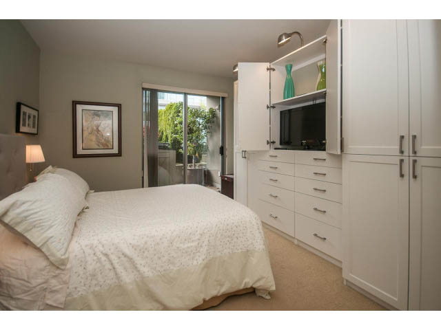 Furnished 2-bedroom condo with built-in cabinets, modern lighting, and a view of greenery outside. - 310 - 160 E 13th St, North Vancouver