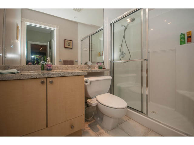 Furnished bathroom with granite countertops and a walk-in shower. - 310 - 160 E 13th St, North Vancouver