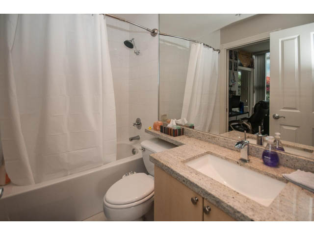 Furnished bathroom with granite countertops and a bathtub/shower combo. - 310 - 160 E 13th St, North Vancouver