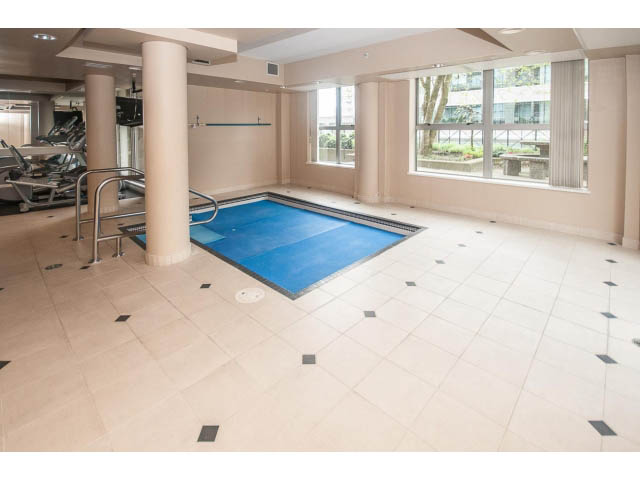 Spacious fitness room with cardio equipment, large windows, and tiled floor. - 310 - 160 E 13th St, North Vancouver