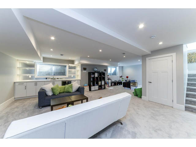 Spacious living room with modern white furniture and large windows. - 3075 Dryden Way, North Vancouver