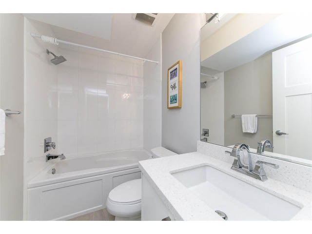 Bright bathroom with white countertop and bathtub, modern fixtures. - 3075 Dryden Way, North Vancouver