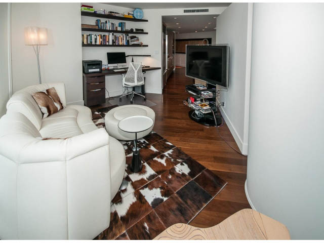 Living room with hardwood floors, cowhide rug, and white furniture. - 1902 - 1111 Alberni Street, Vancouver Downtown