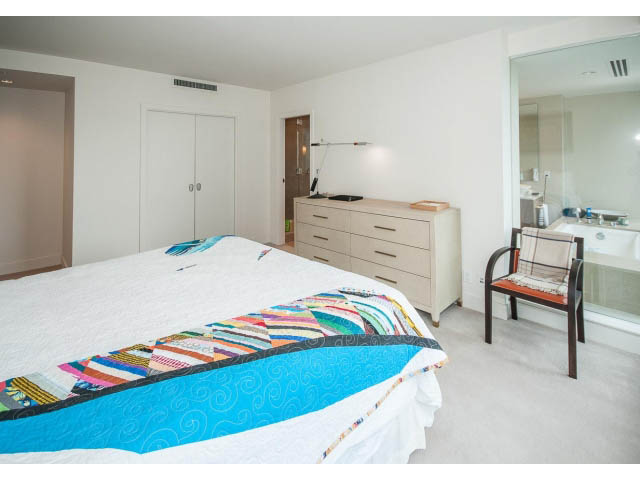 Bright bedroom with a colorful patchwork quilt, modern furniture, and a large mirror. - 1902 - 1111 Alberni Street, Vancouver Downtown