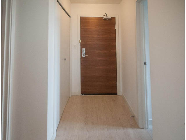 Bright hallway with wooden door and light-colored walls. - 501 - 161 West Georgia St, Vancouver Downtown