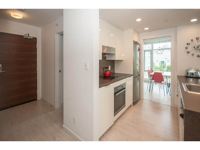 Bright kitchen with white cabinets, hardwood floors, and a city view. - 501 - 161 West Georgia St, Vancouver Downtown