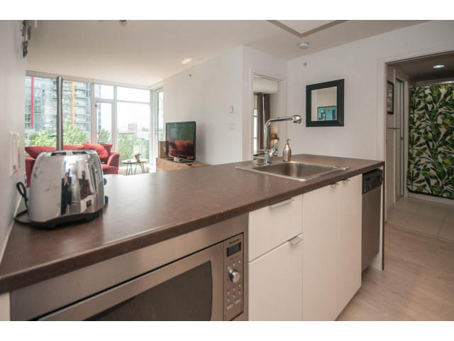 Bright kitchen with modern appliances, hardwood floors, and a city view. - 501 - 161 West Georgia St, Vancouver Downtown