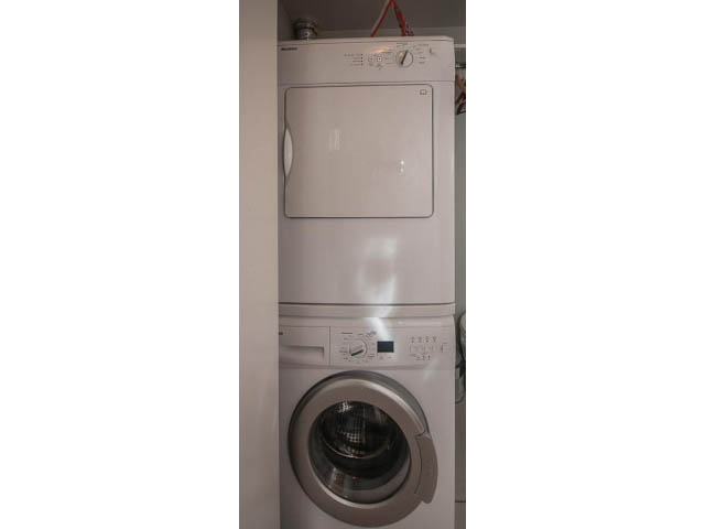 Bright laundry room with stacked washer and dryer. - 501 - 161 West Georgia St, Vancouver Downtown