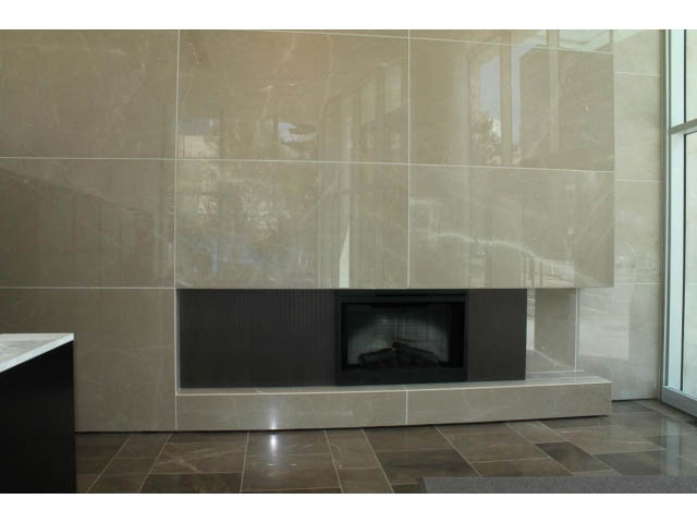 Spacious living room with modern tile fireplace and large windows. - 501 - 161 West Georgia St, Vancouver Downtown