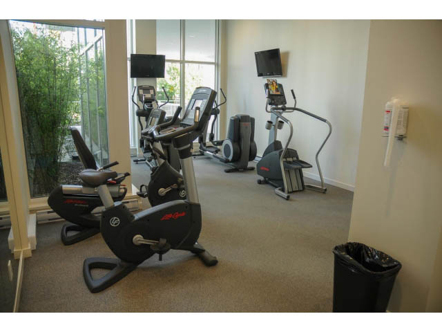 Bright fitness room with cardio equipment and large windows. - 501 - 161 West Georgia St, Vancouver Downtown