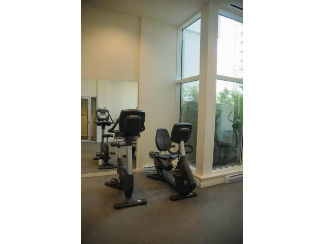 Bright living room with exercise bikes and large windows, offering a city view. - 501 - 161 West Georgia St, Vancouver Downtown