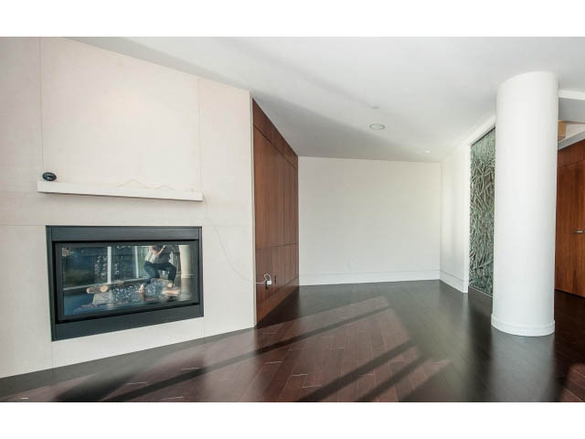 Spacious living room with modern fireplace, hardwood floors, and glass accents. - 1502- 1560 Homer Mews, Vancouver Downtown