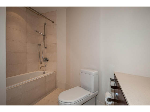 Compact bathroom with white fixtures and beige tiles. - 1502- 1560 Homer Mews, Vancouver Downtown