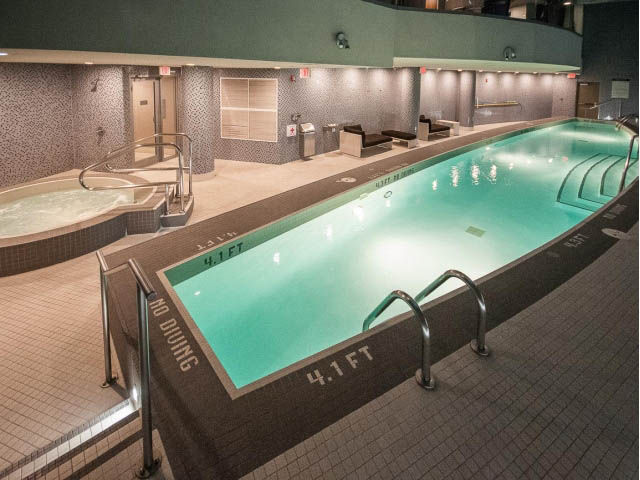 Spacious indoor pool area with tiled walls and floor, hot tub, and depth markers. - 1502- 1560 Homer Mews, Vancouver Downtown
