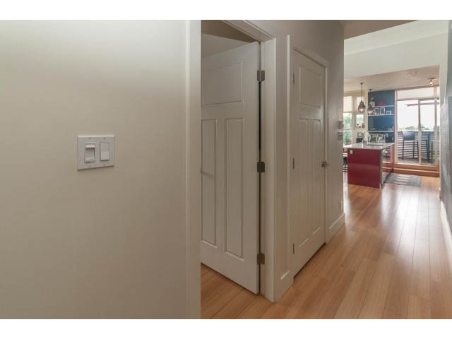 Bright hallway leading to a cozy kitchen with hardwood floors and a city view. - 4123 - 2250 Commercial Dr, Vancouver East Side