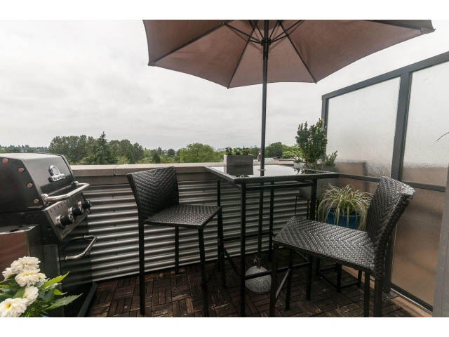 Furnished rooftop patio with outdoor seating, grill, and umbrella, overlooking greenery. - 4123 - 2250 Commercial Dr, Vancouver East Side