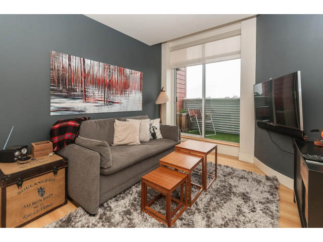 Furnished living room with modern decor, large window, and city view. - 4123 - 2250 Commercial Dr, Vancouver East Side