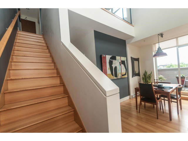 Furnished loft with wooden stairs, hardwood floors, and a dining area. - 4123 - 2250 Commercial Dr, Vancouver East Side