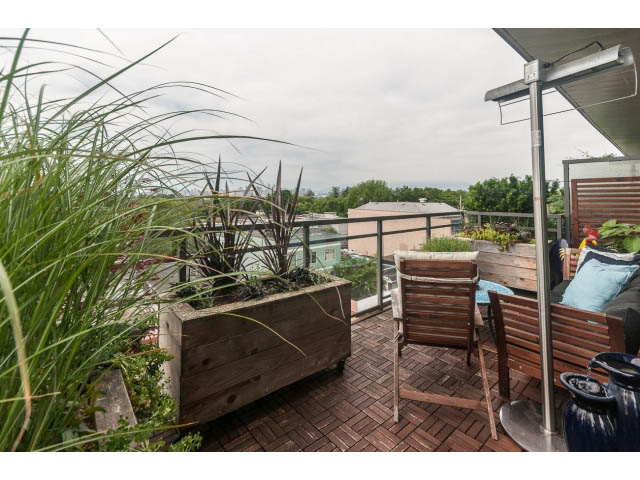 Furnished rooftop patio with wooden furniture, plants, and city view. - 4123 - 2250 Commercial Dr, Vancouver East Side