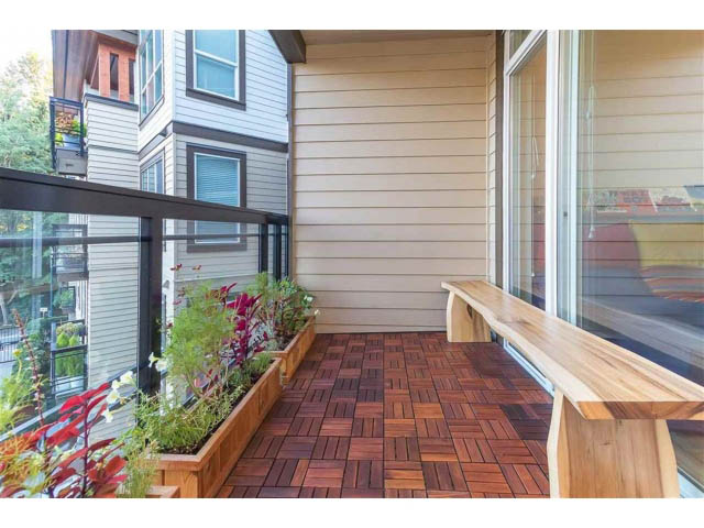 Furnished balcony with wooden flooring and outdoor plants. - 305 - 3205 Mountain Highway, North Vancouver