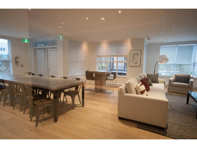 Furnished living room with hardwood floors and large windows. - 305 - 3205 Mountain Highway, North Vancouver