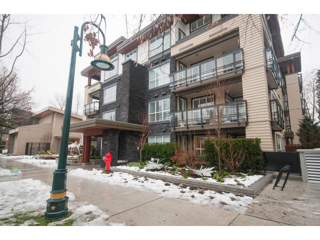 Furnished 1-bedroom + den condo with modern balcony and snow-covered landscaping. - 305 - 3205 Mountain Highway, North Vancouver
