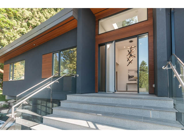 Modern entrance with glass railings and stone steps leading to a spacious, well-lit interior. - 460 Hillcrest Street, West Vancouver