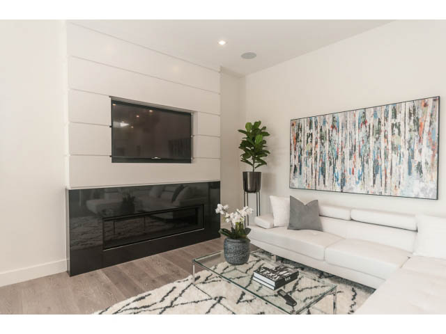 Spacious living room with modern fireplace, abstract art, and white furniture. - 460 Hillcrest Street, West Vancouver