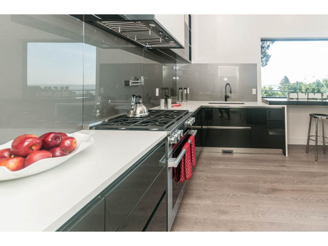 Bright kitchen with modern black cabinetry, white countertops, and hardwood floors, featuring a city view. - 460 Hillcrest Street, West Vancouver