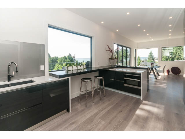 Bright kitchen with modern black cabinets, hardwood floors, and a city view. - 460 Hillcrest Street, West Vancouver