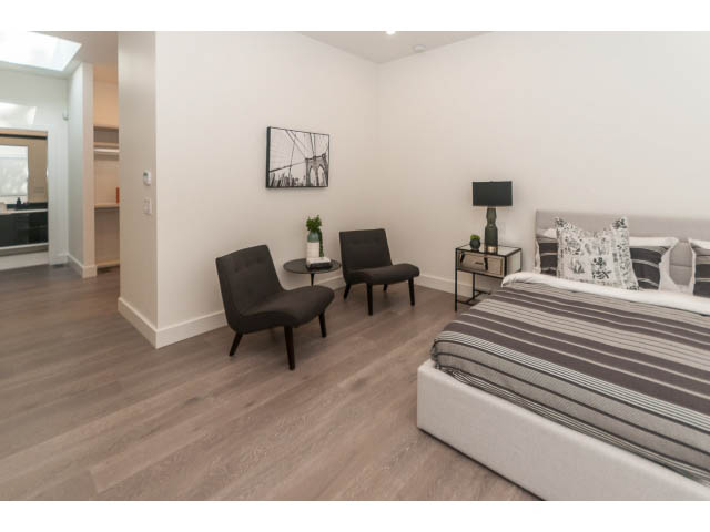 Spacious bedroom with hardwood floors, modern furniture, and a large bed. - 460 Hillcrest Street, West Vancouver