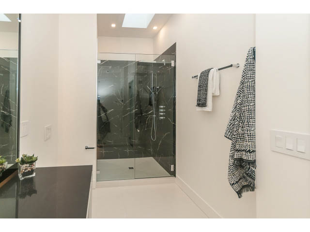 Modern bathroom with black marble accents and a glass shower. - 460 Hillcrest Street, West Vancouver