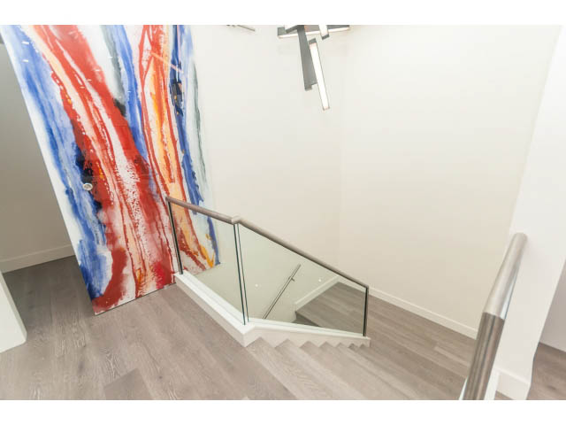 Staircase with glass railings and colorful abstract art. - 460 Hillcrest Street, West Vancouver