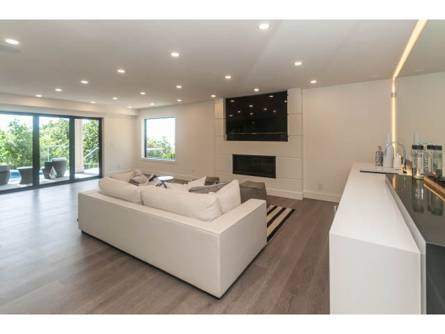 Bright living room with modern white furniture, hardwood floors, and a city view. - 460 Hillcrest Street, West Vancouver