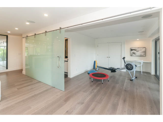 Bright exercise room with hardwood floors and a red exercise bike. - 460 Hillcrest Street, West Vancouver