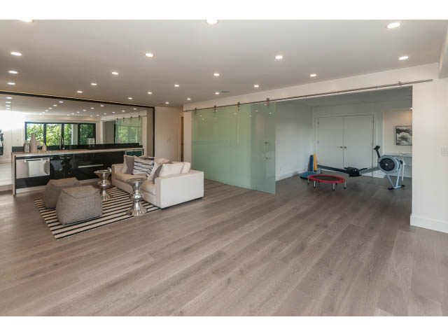 Spacious living room with hardwood floors and sliding glass doors leading to a balcony. - 460 Hillcrest Street, West Vancouver