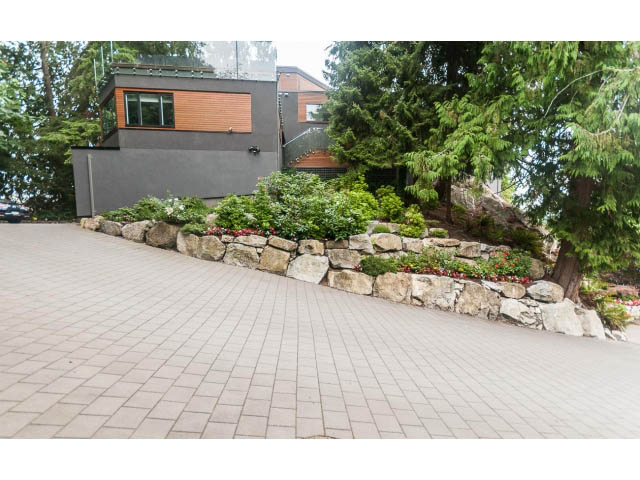 Spacious patio with stone accents and lush greenery. - 5385 Kew Cliff Rd, West Vancouver