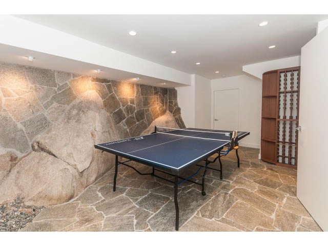 Game room with stone walls and ping pong tables. - 5385 Kew Cliff Rd, West Vancouver