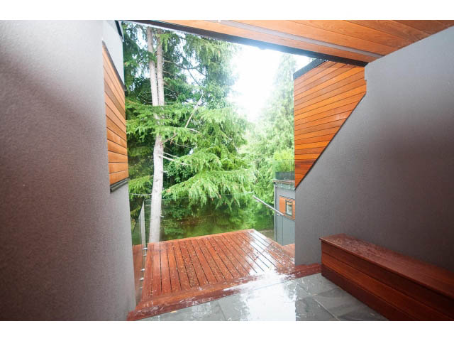 Bright living room with wooden deck and forest view. - 5385 Kew Cliff Rd, West Vancouver