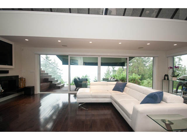 Spacious living room with hardwood floors, large windows, and modern furniture. - 5385 Kew Cliff Rd, West Vancouver